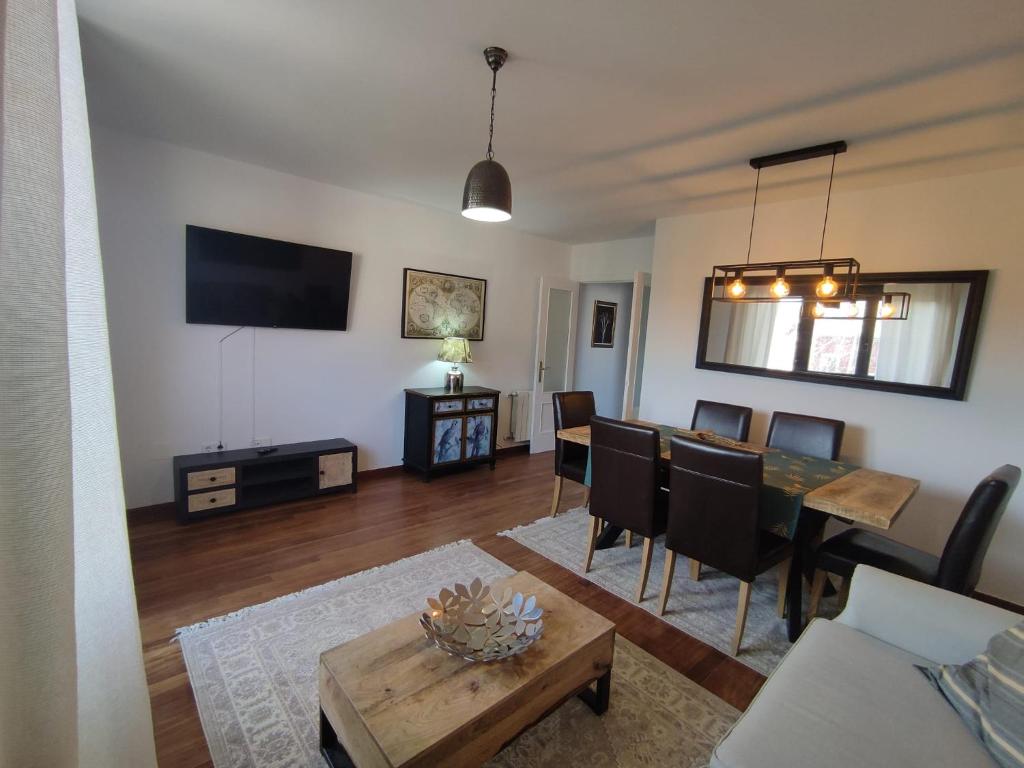 ein Wohnzimmer mit einem Tisch und einem Esszimmer in der Unterkunft Apartamento 6 personas Playa de Covachos in Soto de la Marina
