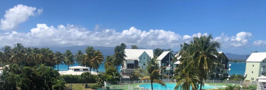 vista su un resort con piscina e palme di VIVA a Le Gosier