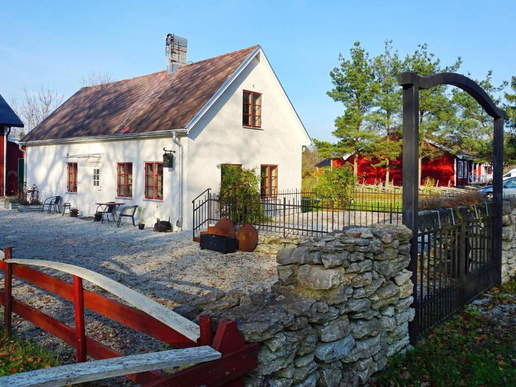 Casa blanca con valla y pared de piedra en Holiday home SLITE III, en Slite