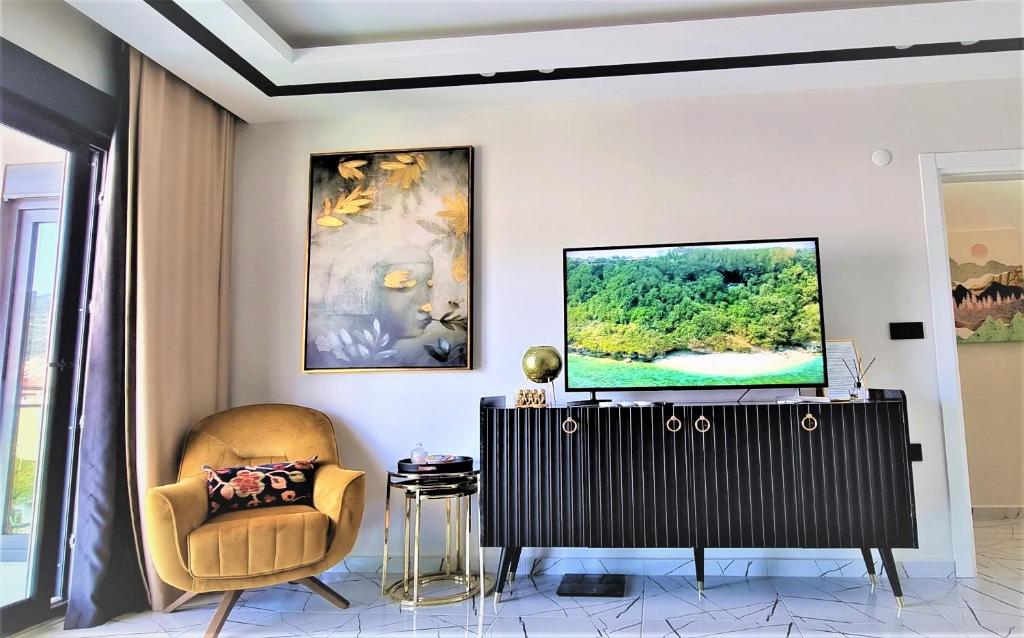 sala de estar con TV y silla en Art City Luxury Residence in the Center of Alanya, en Alanya
