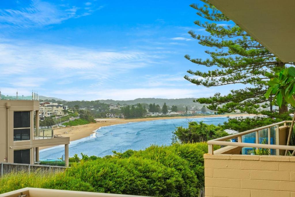a view of the beach from the balcony of a house at Cosy Beachside Unit, Short Stroll to the Beach in Terrigal