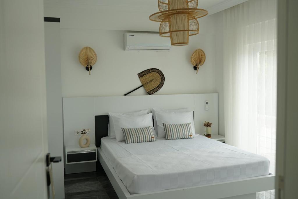 a white bedroom with a bed with white sheets at Blue Island Luxury Hotel Adults Only in Kaş