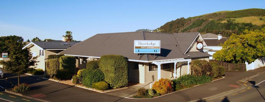 ein Haus mit einem Schild darüber in der Unterkunft Riverlodge Motel in Nelson