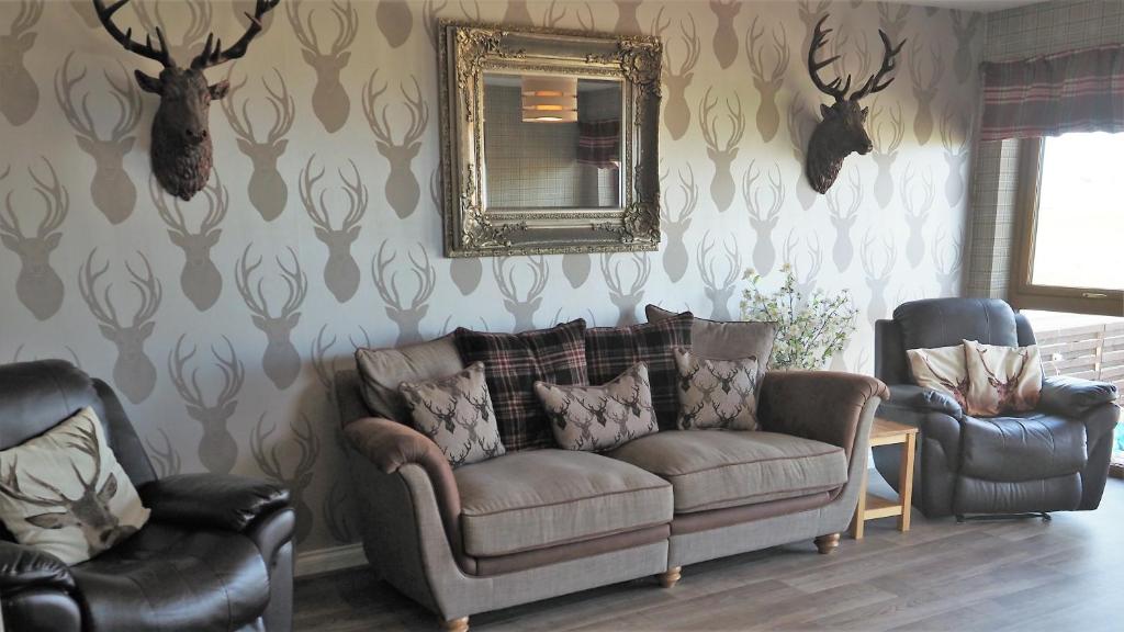 uma sala de estar com um sofá, 2 cadeiras e um espelho em Valhalla Brae, 3 Bed House on NC500 with Beautiful Castle and Sea Views em Keiss