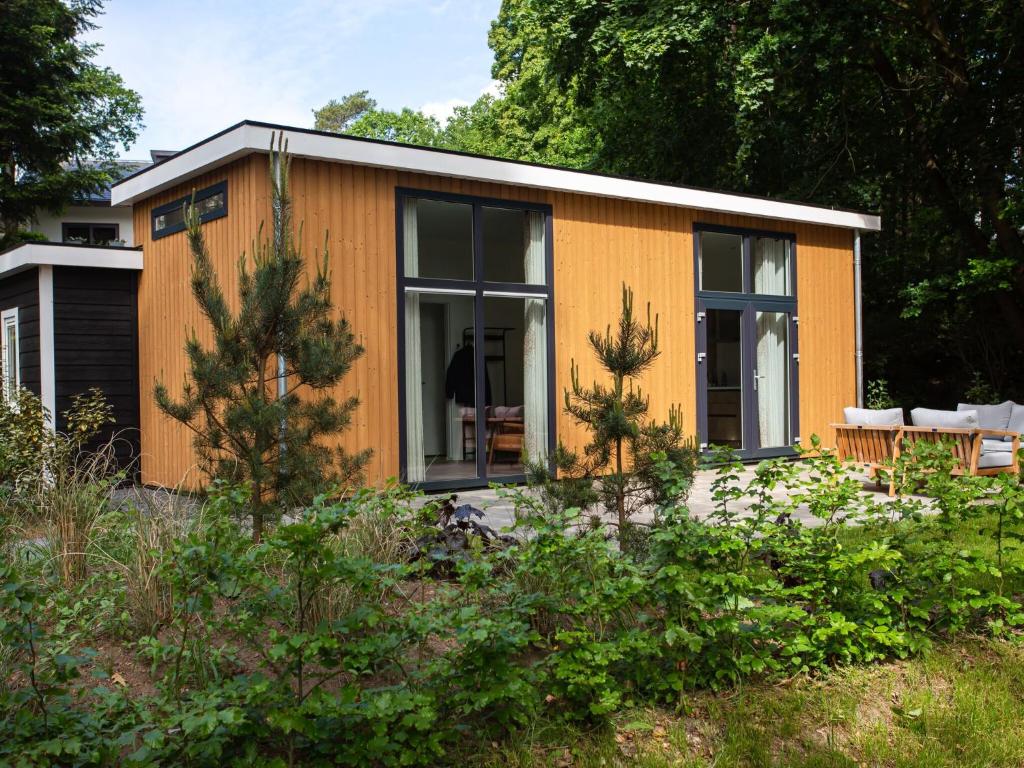 una piccola casa arancione in un giardino di Modern house with dishwasher, on a holiday park in a nature reserve a Rhenen