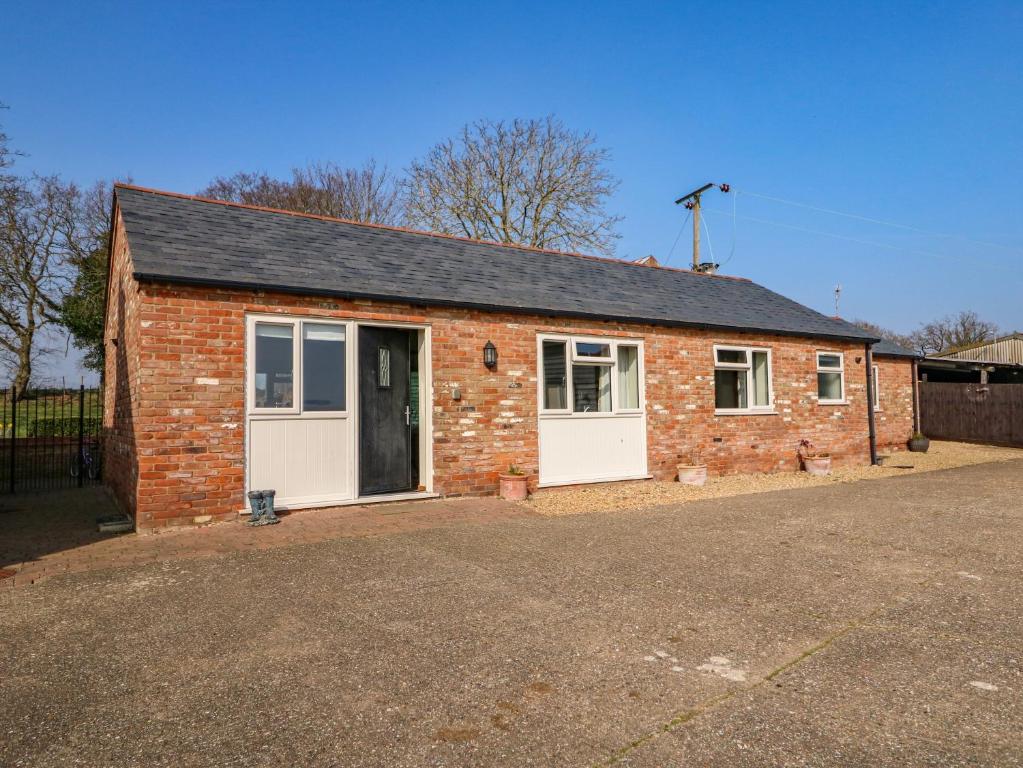 una casa de ladrillo con puertas blancas y entrada en Sunnyside Cottage, en Middleton