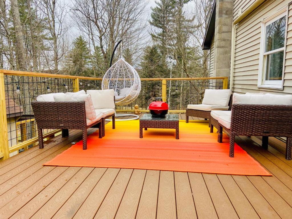 a deck with two chairs and a red rug at Sylvan Rhapsody- Stowe Village classic in Stowe