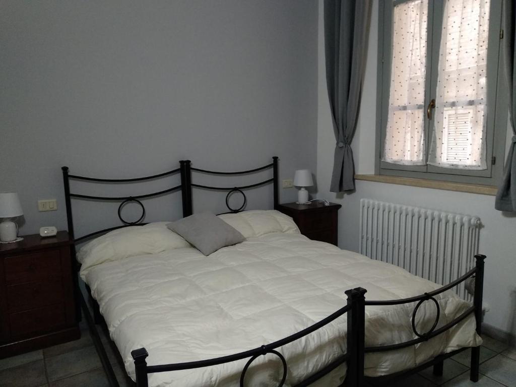 ein Schlafzimmer mit einem großen Bett mit weißer Bettwäsche in der Unterkunft Dietro le quinte nel cuore di Perugia in Perugia