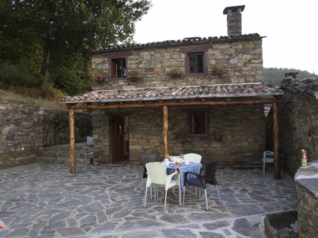 a patio with a table and chairs in front of a building at Casa Princesa Peralta in Lousã