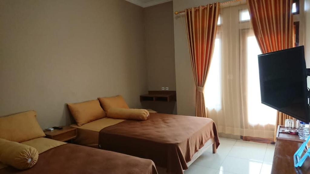 Un pat sau paturi într-o cameră la Villagio Hotel