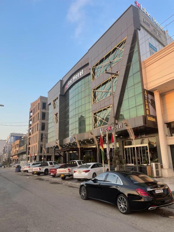 a large building with cars parked in front of it at Lilac Hotel in Erbil