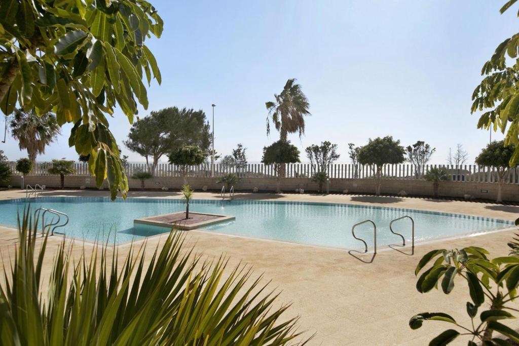 a swimming pool in a yard with a fence at Beautiful Duplex Facing The Beach in El Médano
