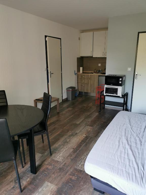 Cette chambre comprend un lit, une table et une cuisine. dans l'établissement Joli Appartement 2 pièces 4 voyageurs tout équipé 13 avenue de la Divette 14390 CABOURG, à Cabourg