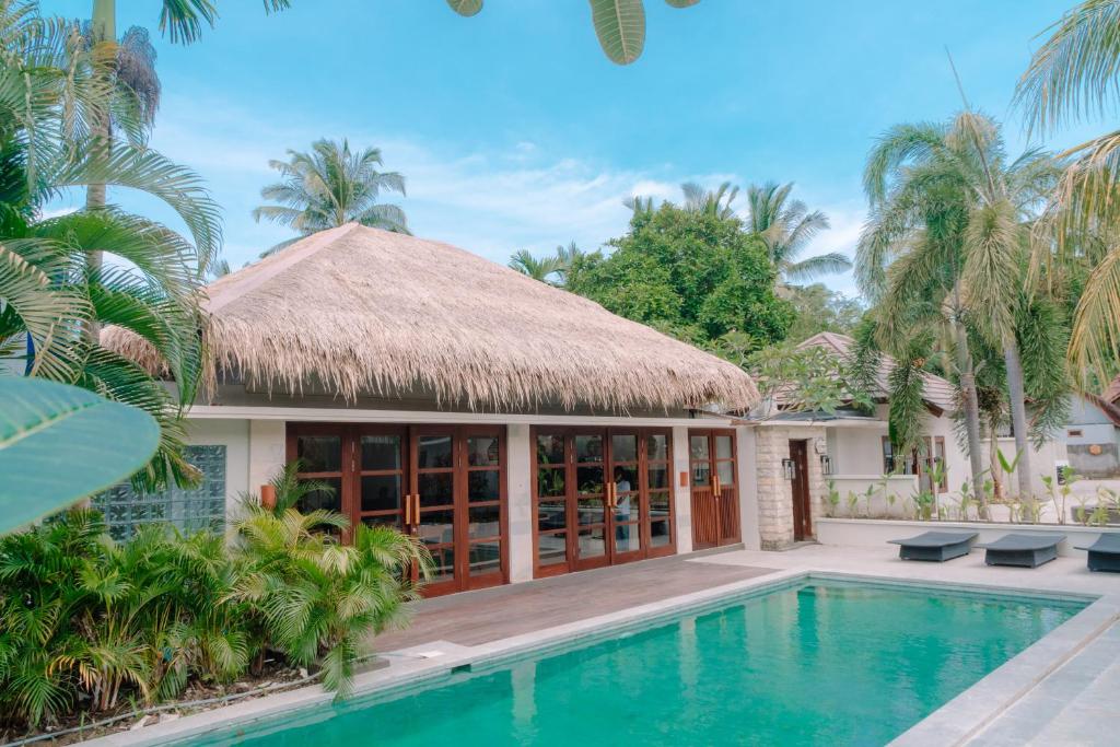 a villa with a swimming pool and a resort at KU Villas in Kuta Lombok
