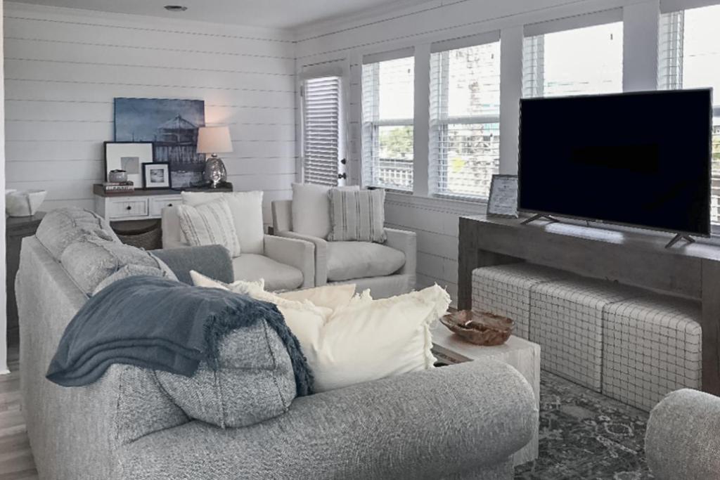 a living room with a couch and a flat screen tv at Mermaid Tales in Dauphin Island