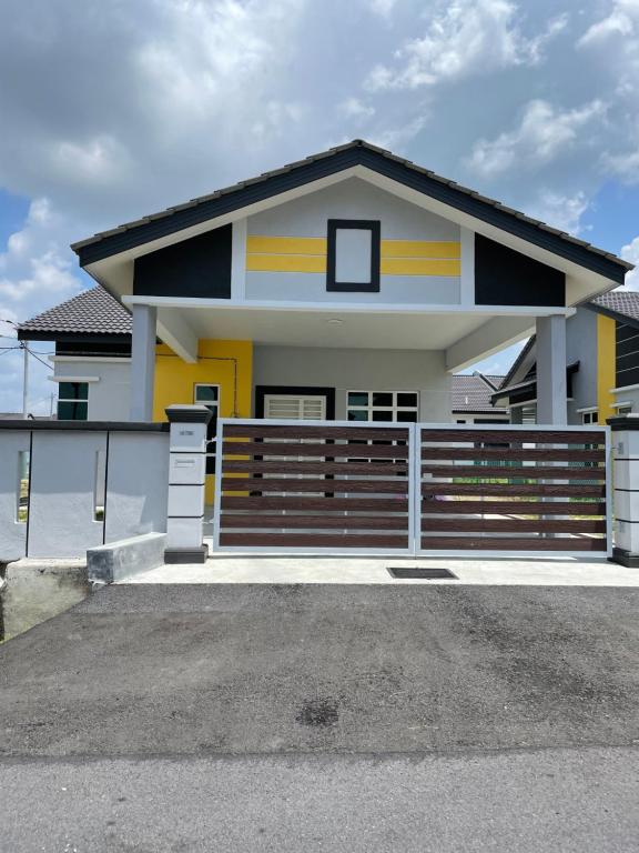 a house with a fence in front of it at BUNGALOW homestay JASIN PERDANA in Jasin