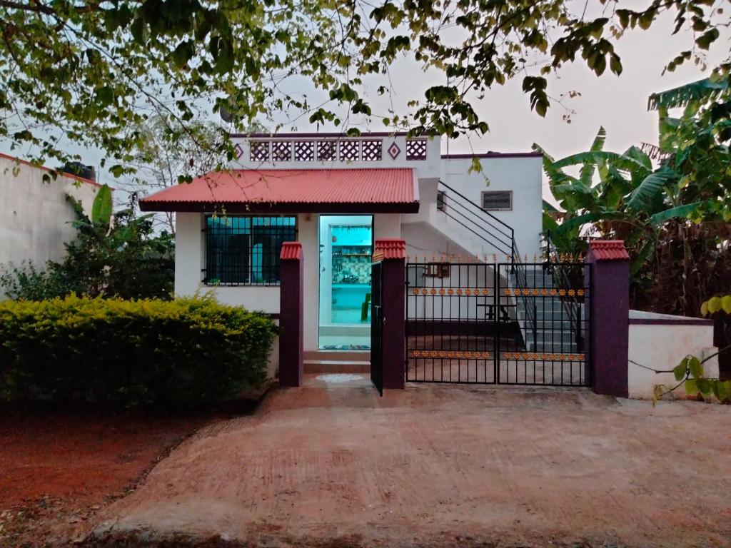 a gate in front of a house with a building at Yelagiri RAM Cottage @Home with kitchenette full in Yelagiri