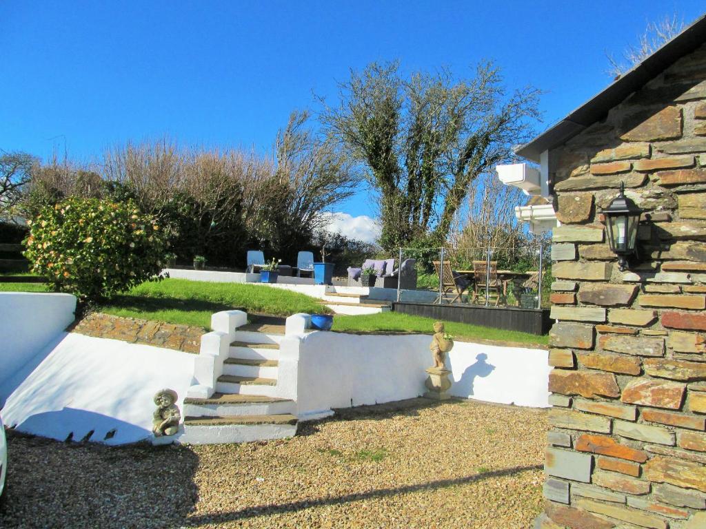 um edifício de pedra com escadas e um hidrante em Heligan Cottage em St Austell