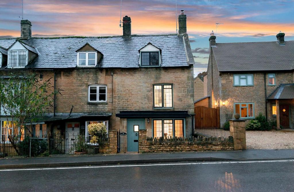 una gran casa de ladrillo al lado de una calle en Eastnor, en Moreton-in-Marsh