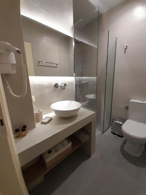 uma casa de banho com um lavatório, um WC e um espelho. em Byzantion Hotel em Mistras