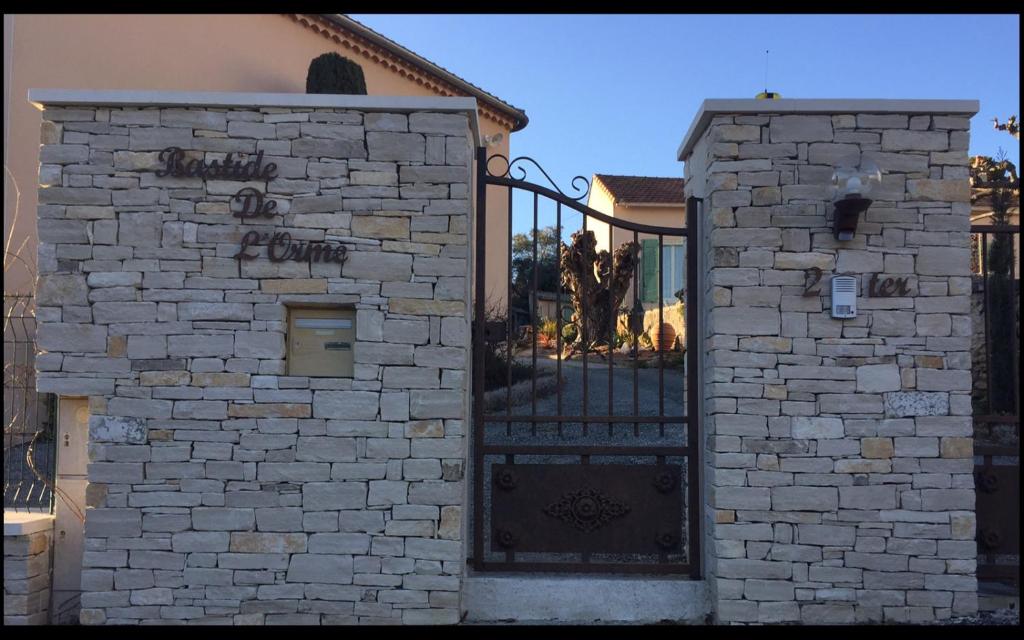 une porte menant à une maison avec un mur en pierre dans l'établissement Bastide de l'orme, à Forcalquier