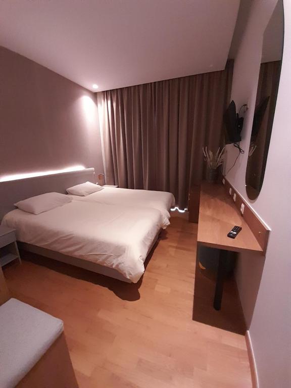 a hotel room with two beds and a television at Byzantion Hotel in Mystras