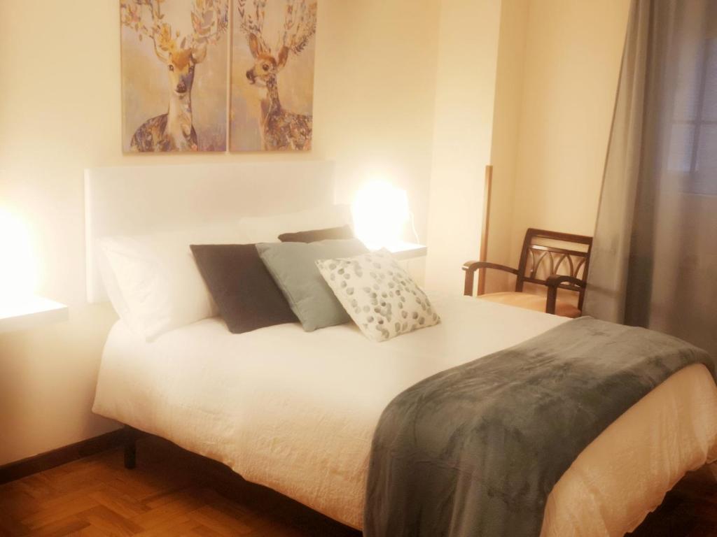 1 dormitorio con 1 cama con 2 almohadas en Apartamento CONFORT BEACH, 300 mtr playa, en Gijón
