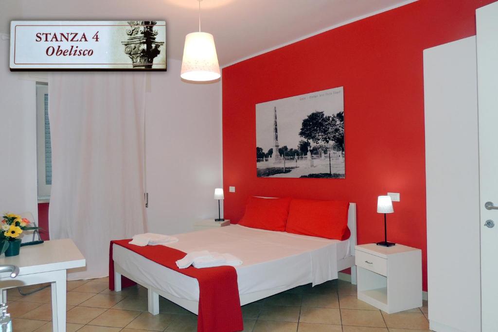 Dormitorio rojo con cama blanca y almohadas rojas en Barocco.Oberdan, en Lecce