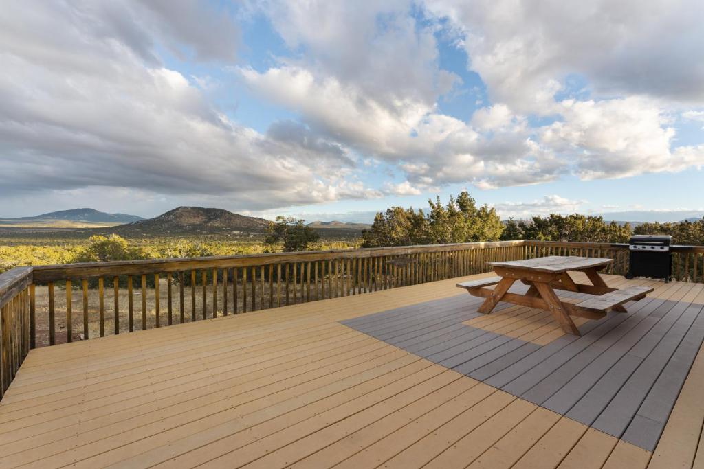una terraza de madera con un banco de picnic en Hillside Cabin~Williams & Grand Canyon Destination, en Williams