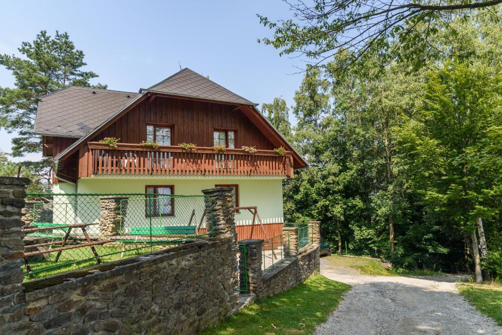 a house with a stone wall in front of it at Apartmány Šumava in Hojsova Stráž