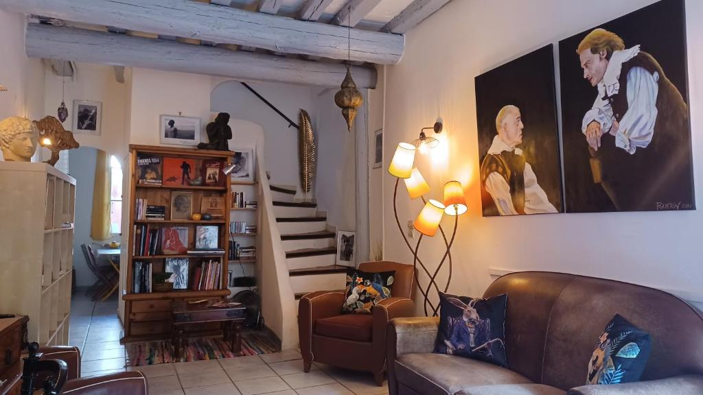 a living room with a couch and a staircase at MAISON DE CHARME AVEC COUR, proche rue des Teinturiers in Avignon