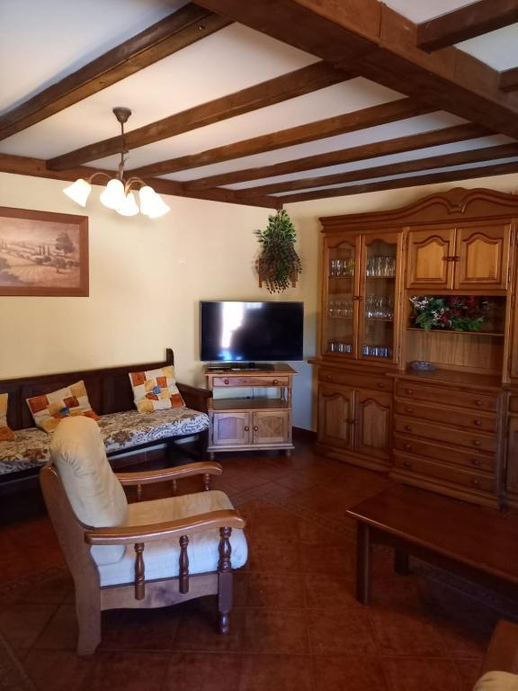 a living room with a couch and a tv at Casa Rural La Cerra in Navalguijo