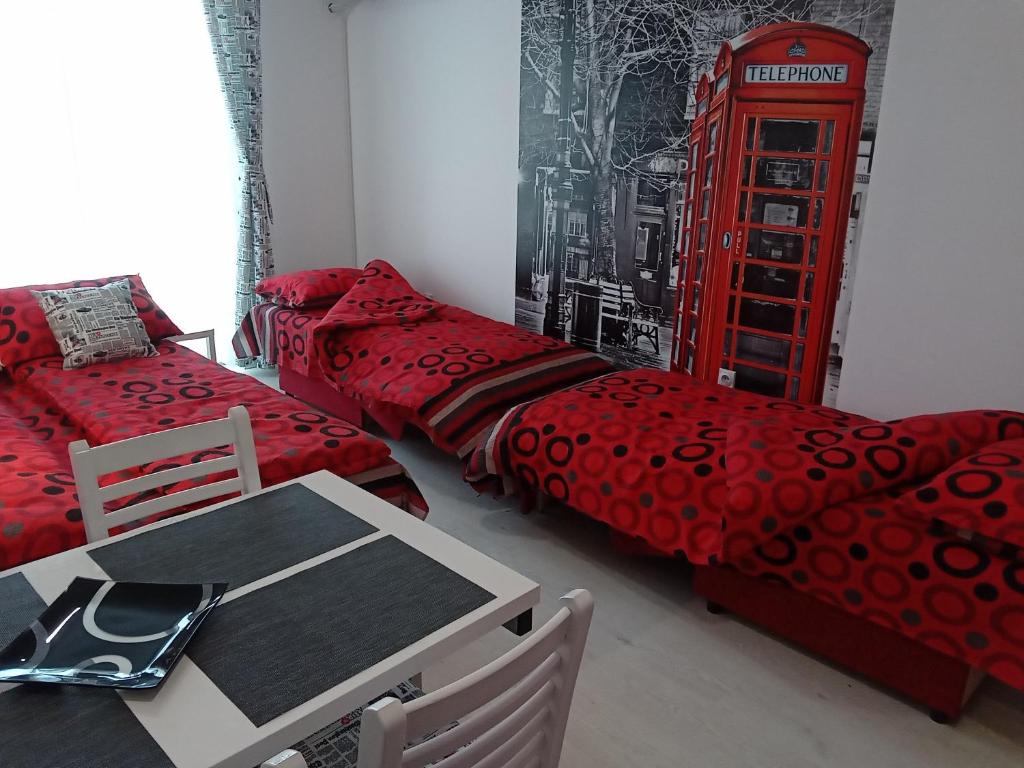 Habitación con cabina de teléfono roja y mesa. en Studio La Casa, en Soko Banja