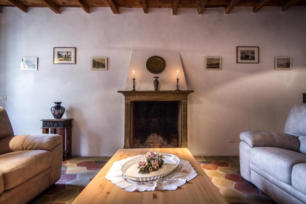 a living room with a table and a fireplace at VECCHIO BORGO in Torno