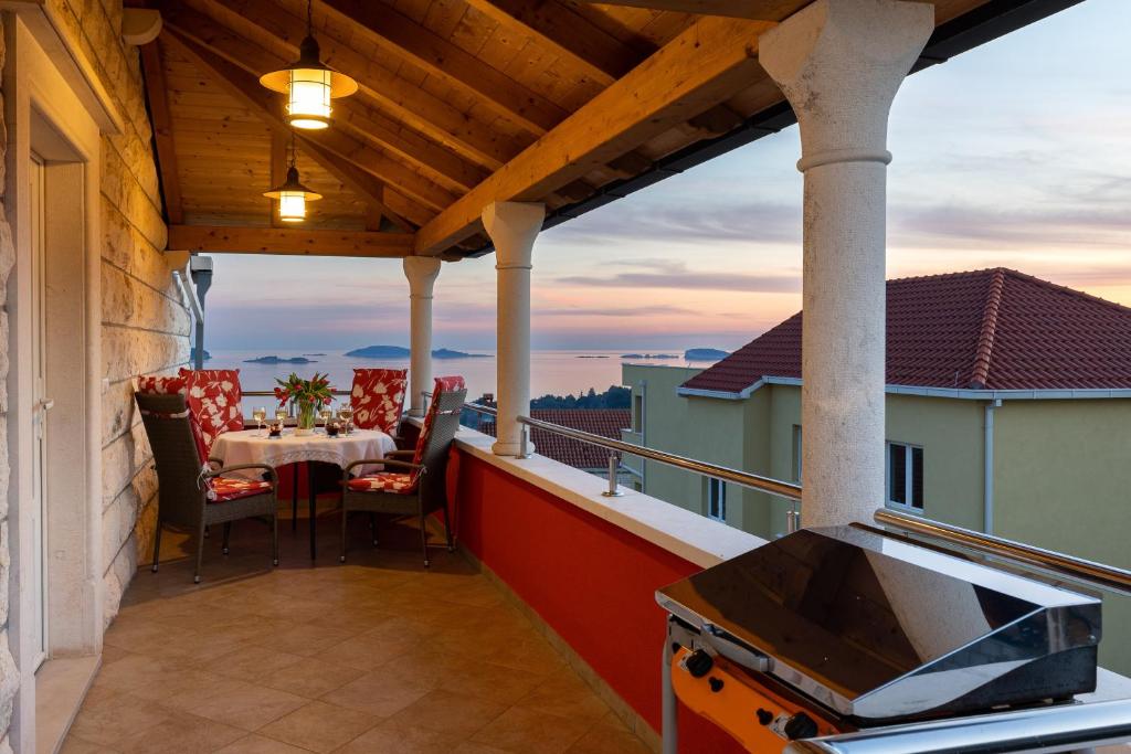 patio con mesa y sillas en el balcón en Apartments Subrenum, en Mlini