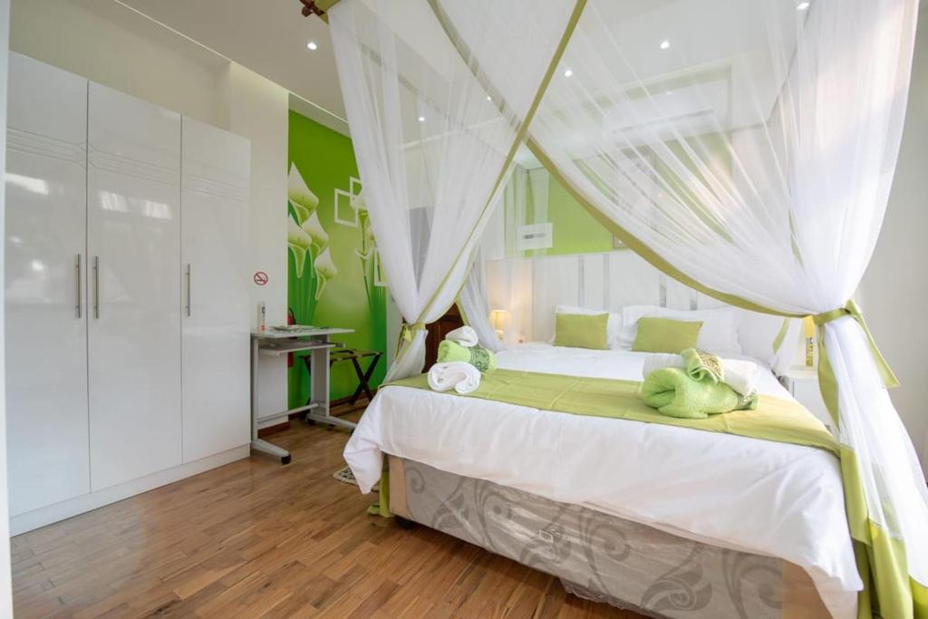 a bedroom with a white bed with a canopy at Casa Quimera in Maputo
