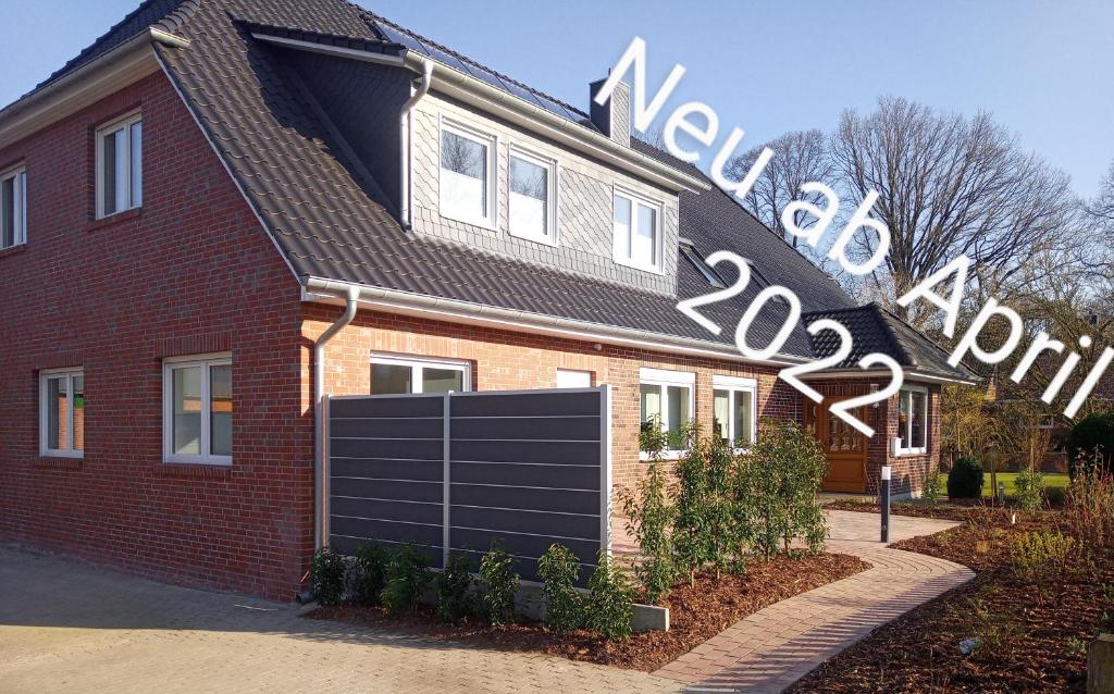 a red brick house with a black garage at Ferienwohnungen Im Dorfe Neu ab April 2022 in Soltau