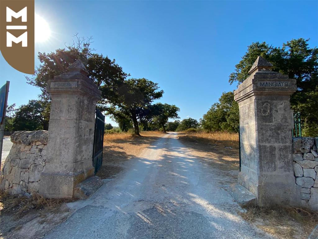 an old stone gate on a dirt road at Masseria Mangiato 1557 in Alberobello