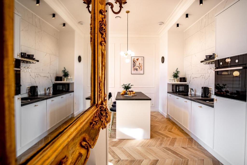 a kitchen with white cabinets and a mirror at Luxury Apartment St. Sebastian in Krakow