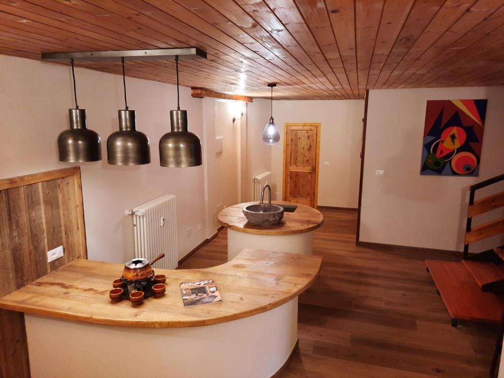 cocina con luces colgantes y encimera en una habitación en Appartamento con taverna nel paese di Morgex, en Morgex