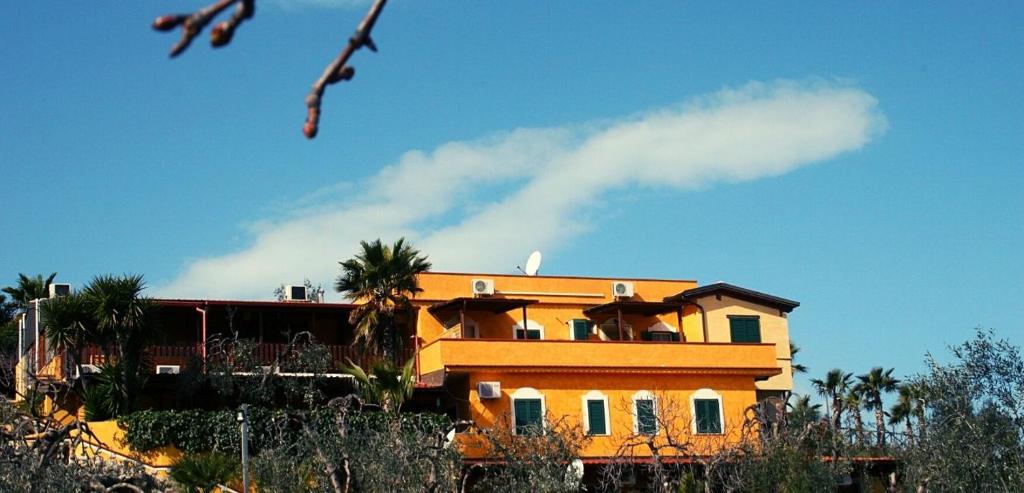 żółty dom z palmami przed nim w obiekcie Villacelest Casa Vacanze Peschici w mieście Peschici