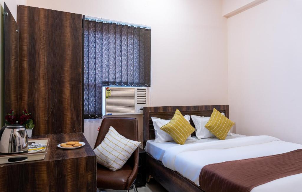 a hotel room with two beds and a table and a chair at Sukoon Pearl inn in Jabalpur