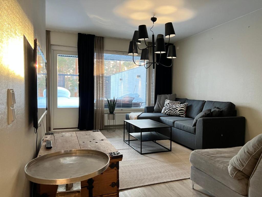 un soggiorno con divano e tavolo di Time Apartments Kärpänkuja a Jyväskylä