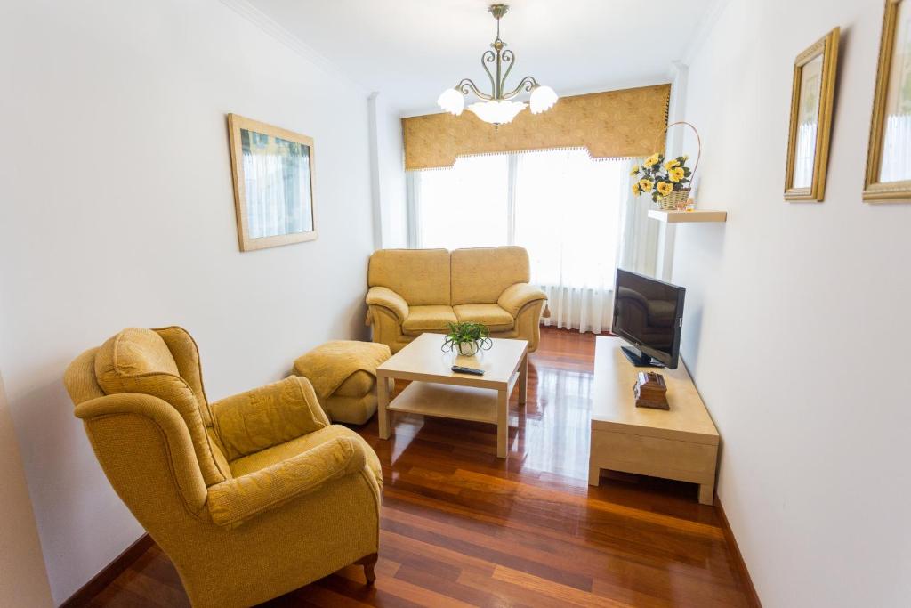 ein Wohnzimmer mit 2 Stühlen und einem TV in der Unterkunft Casa Goros II in Melide