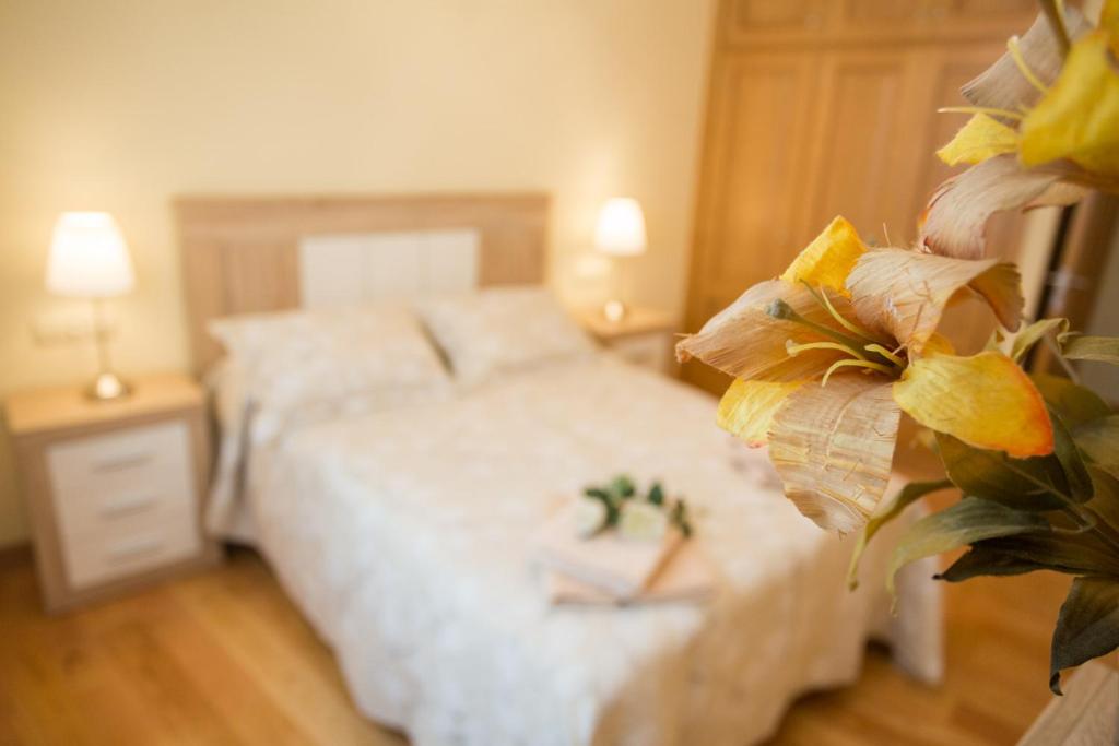 a bedroom with a white bed and two lamps at Casa Goros in Melide