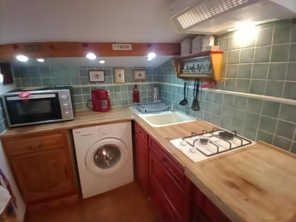 a kitchen with a sink and a washing machine at Gîte Chez Dado &amp; Denis Saint Martin d&#39;Ardèche in Saint-Martin-dʼArdèche