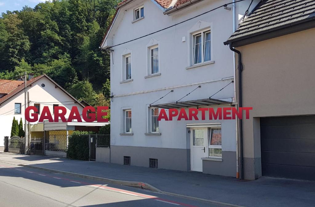 un edificio blanco con un cartel de acuerdo de garaje en él en Park en Liubliana