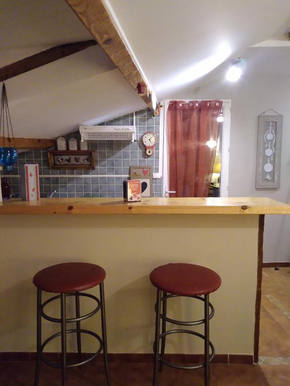a kitchen with two stools at a bar at Gîte Chez Dado &amp; Denis Saint Martin d&#39;Ardèche in Saint-Martin-dʼArdèche