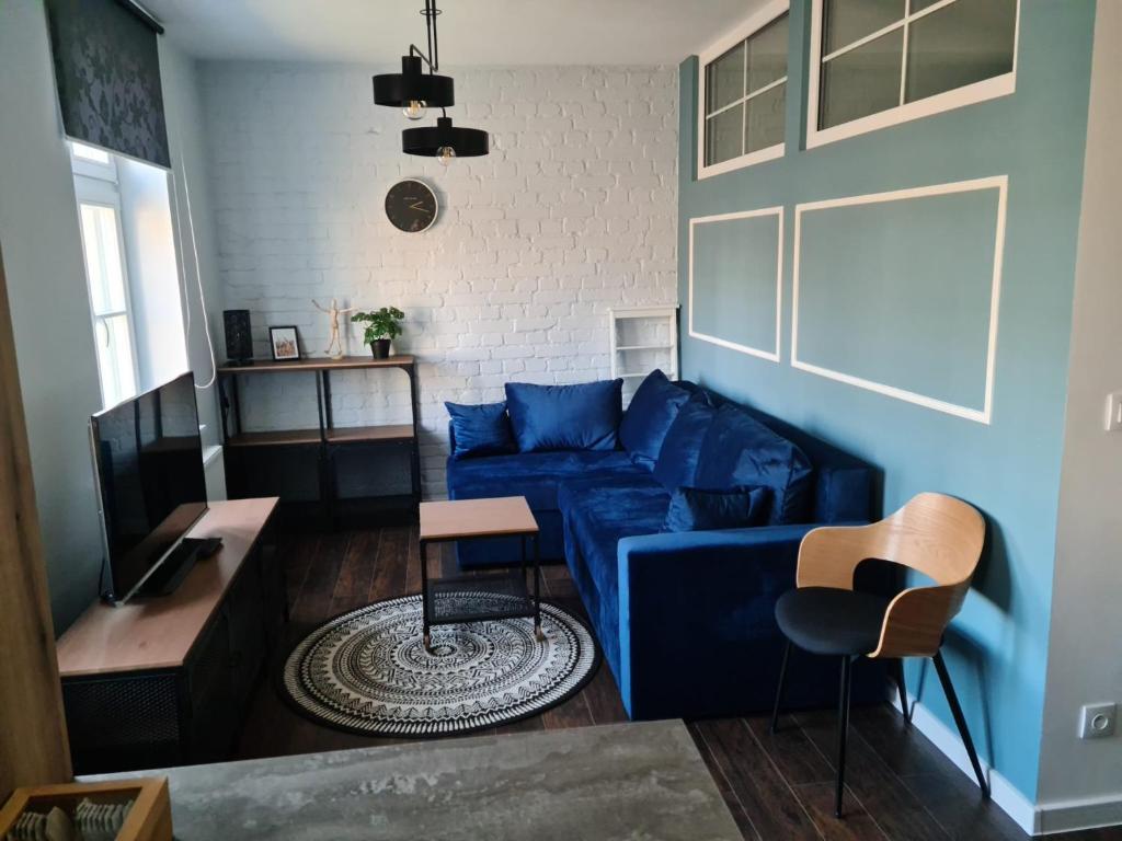 ein Wohnzimmer mit einem blauen Sofa und einem Tisch in der Unterkunft APARTAMENT CENTRUM OLSZTYNA 2 in Olsztyn
