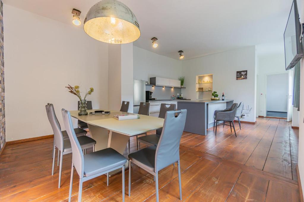 uma sala de jantar e cozinha com mesa e cadeiras em Exklusive Stadtvilla-190qm- Parkplatz- 3Schlafzimmer- 2 Bäder- Netflix- Waschmaschine- 4 Etagen-nähe Theater em Cottbus